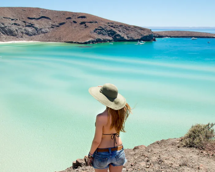 Mujer mirando la playa desde arriba